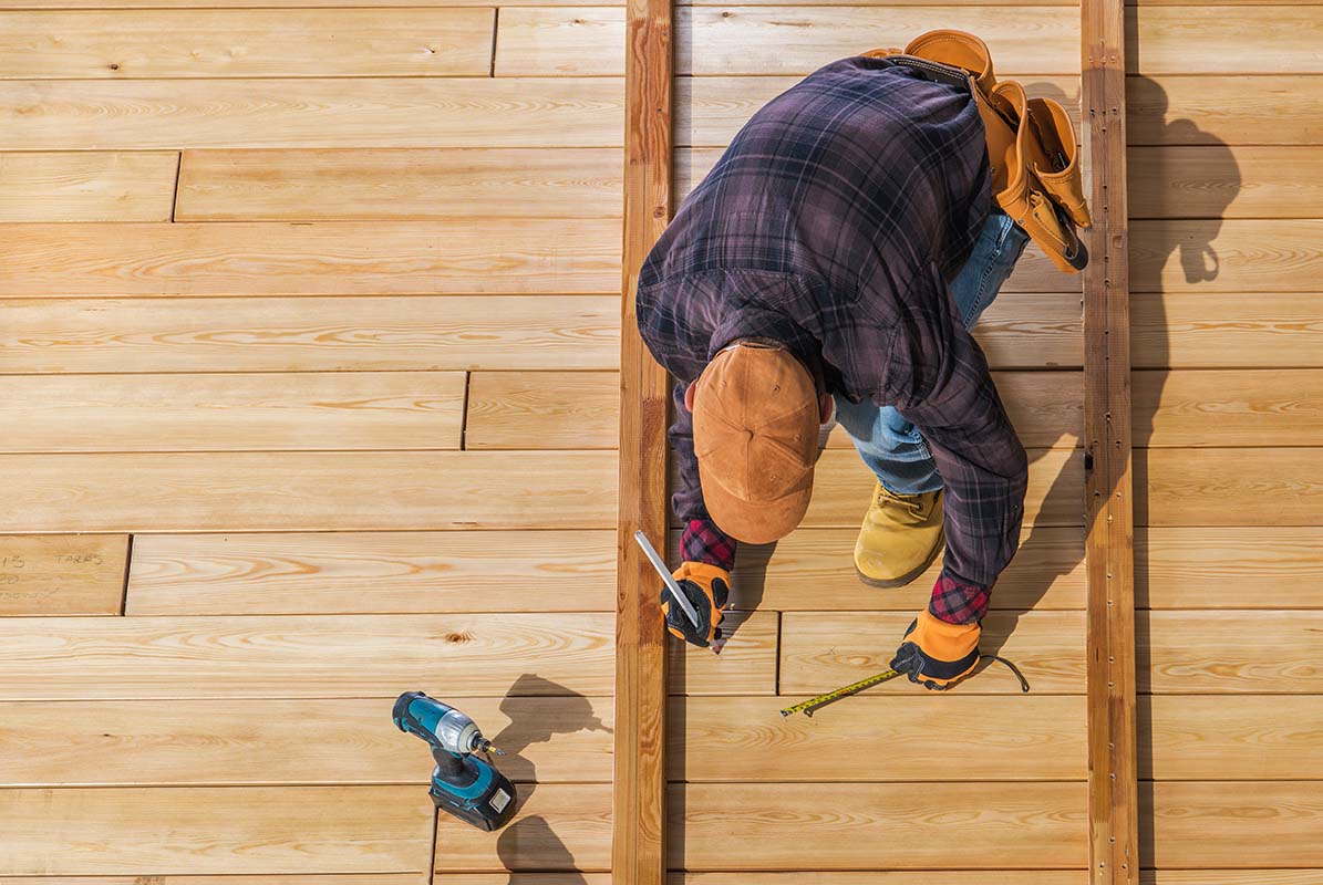 deck builder constructing a wooden deck